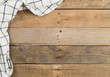 © Shawn Hempel - Blue and white checkered dishcloth on brown rustic wooden plank table flat lay top view from above