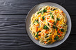 Italian vegetarian spaghetti with pumpkin, spinach and cheddar cheese close-up on a plate. Horizontal top view