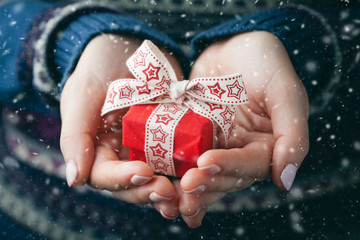 Close up shot of female hands holding a small gift