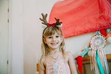 Cute little girl with reindeer horns smiling