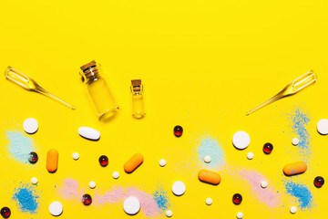 Wall Mural - Yellow medical pharmaceutical background. Multicolored pills top view. childhood diseases. place for text. Copy space