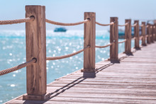 View At The Sea From The Wooden Pier With Posts And Ropes With Sparkling Sea Water, Vacation Destination Concept