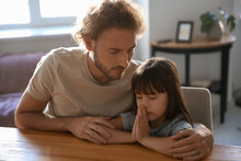 Father With Daughter Praying At Home