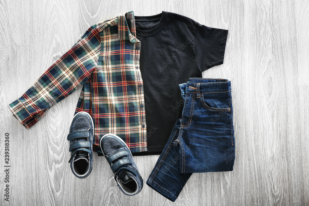 Stylish outfit with shoes on wooden background