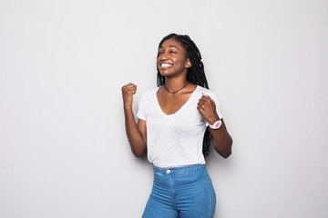 Wall Mural - Portrait of a happy young african woman celebrating success isolated over gray background