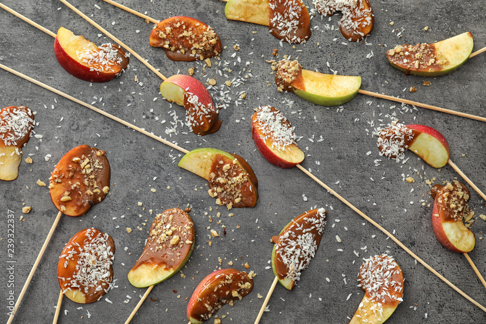 Sticks with candy apple wedges on grey background