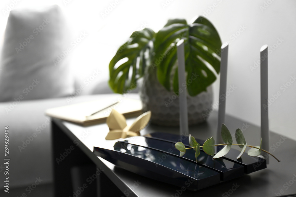 Modern wi-fi router on dark table in room