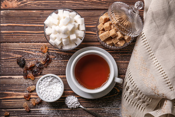 Wall Mural - Different sugar with cup of tea on wooden table