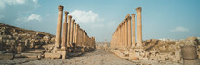 A View Looking Down The Cardo Showing Stone Carved Columns And Paved Street At The Ancient City Of Jarash Or Gerasa, Jerash In Jordan. Ancient Roman Sights. Panorama.