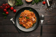 Plate with delicious pasta bolognese on dark wooden table
