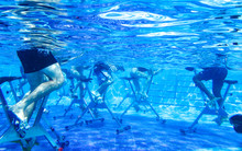 Touristen Doing Aqua Aerobics On Exercise Bikes In Swimming Pool Tropical Hotel
