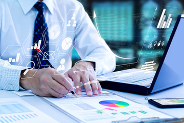 Wall Mural - Businessman looking into a laptop computer notebook deeply reviewing a financial report for a return on investment or investment risk analysis.