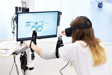 Woman on stand with virtual reality device for rehabilitation