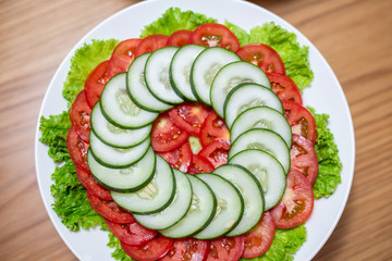 Salad, cucumber and tomato in a white dish