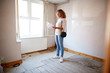 © Monkey Business - Female First Time Buyer Looking At House Survey In Room To Be Renovated