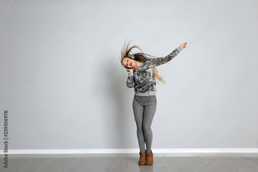 Young female dancer against white wall