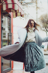 shopping, street fashion, style, people concept - model woman posing for photo outdoor. woman dressed in minimalistic brown - gray coat with a collar posing for photo walking