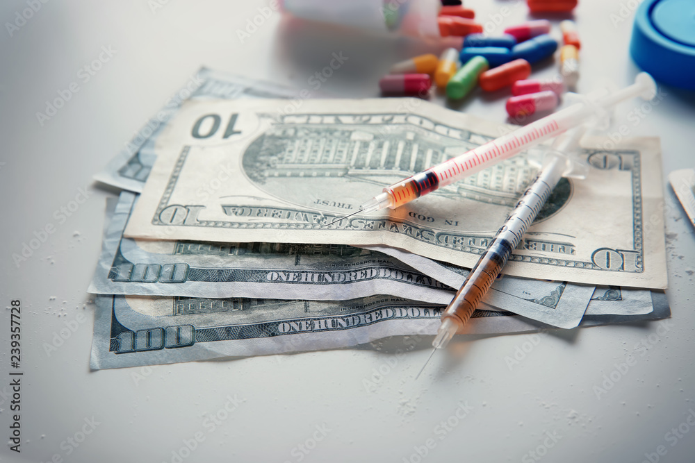 Drugs with money on white background. Concept of addiction