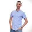 © Elena Kharichkina - Casually handsome. Confident young handsome man in jeans shirt keeping arms crossed and smiling while standing against white background