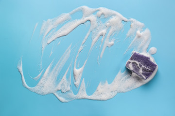 Soap bar with foam on color background