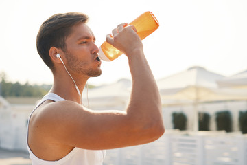 Runner drink water after intensive morning run