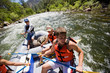 © Erickson Stock - Teenage boy and friends rafting along a river.