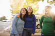 © Erickson Stock - Three laughing young woman standing side by side on a suburban street.