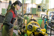 Metalwork Industry. Factory Woman Turner Working On Workshop Lathe Machine