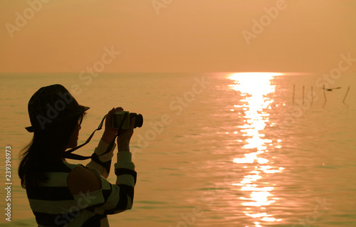 Silhouette Of A Woman Taking Pictures At The Sun Rising