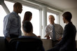© Erickson Stock - Mature man holding a document and gesturing while speaking during a meeting with his business colleagues inside an office.