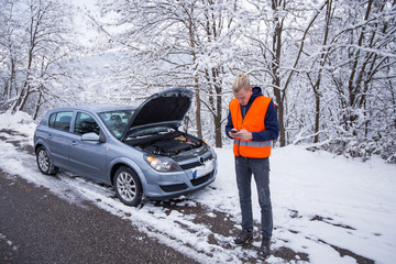 Young man calling for car service,have problem with car at winter day