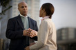 © Erickson Stock - Mid-adult man standing with his hands clasped while having a conversation with a woman on an inner city street.
