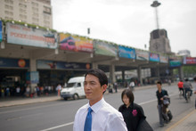 Mid-adult Businessman Walking Along The Road.