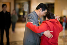Mid-adult Business Man And Woman Dancing In A Hotel Lobby.