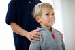 © Erickson Stock - Boy with brother standing indoors