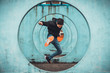 © Urbanscape - Young Asian active man jumping and kicking action, circle looping wall background. Extreme sport activity, parkour outdoor free running, or healthy lifestyle concept