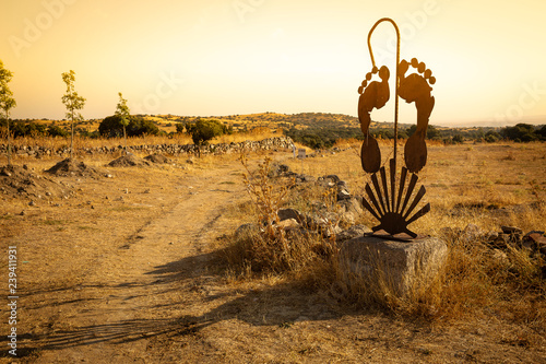 Fotomural rusty metallic structure with a walking stick, feet and a shell (at sunrise) sym