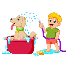 a boy is cleaning his brown dog in the red pail with water and soap 