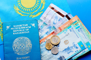 Kazakhstan passport, money and flag on a blue background close up