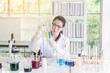 © gballgiggs - Scientist female working putting medical chemicals sample in test tube at laboratory