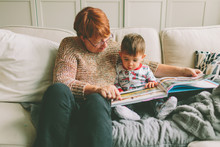 A Grandmother And Her Grandson Reading Together. 