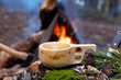 wooden finnish mug, called Kuksa on the stump, with camp fire