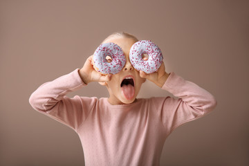 Sticker - Cute little girl with donuts on color background