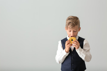 Poster - Cute little boy with donut on light background