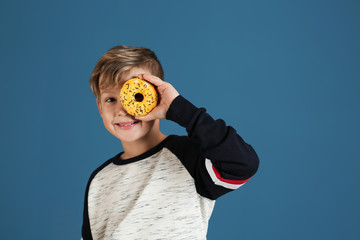 Sticker - Cute little boy with donut on color background