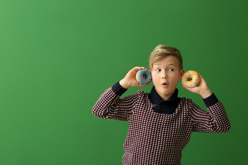 Sticker - Surprised little boy with donuts on color background