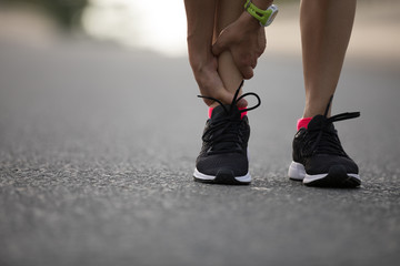 Poster - woman runner hold her injured leg on road