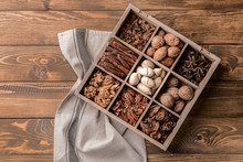 Assortment Of Nuts And Spices In Divided Box On Wooden Table