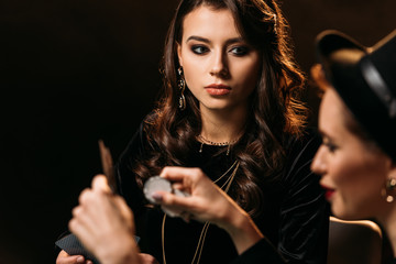 selective focus of attractive girls playing poker in casino