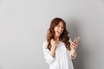 Poster - Cheerful asian woman standing isolated over gray